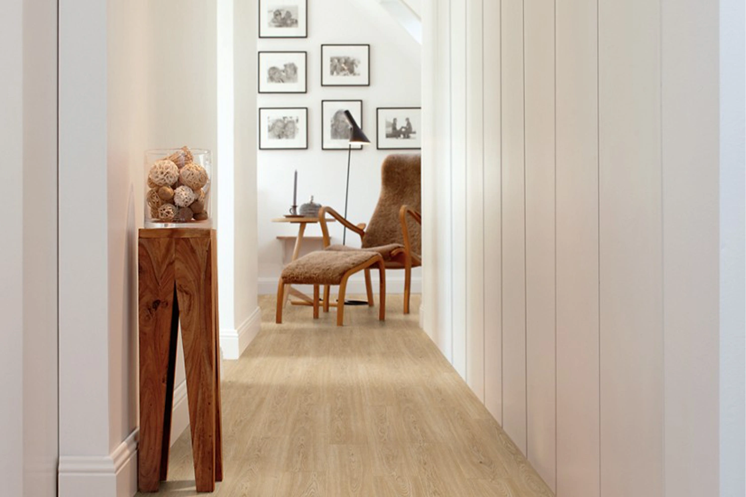 Przedpokój z jasną podłogą laminowaną, białymi ścianami i eleganckimi dodatkami